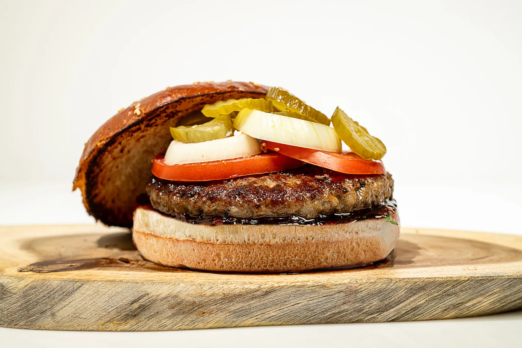 לחמניית המבורגר אנגוס בתוספת עגבניה בצל ומלפפון חמוץ